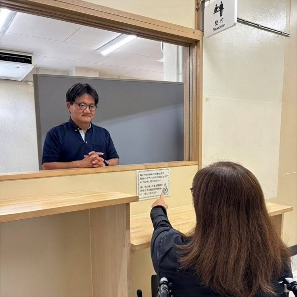 受付で階段昇降車の利用を伝えている様子